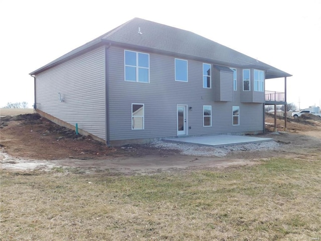 back of property with a patio area and a lawn