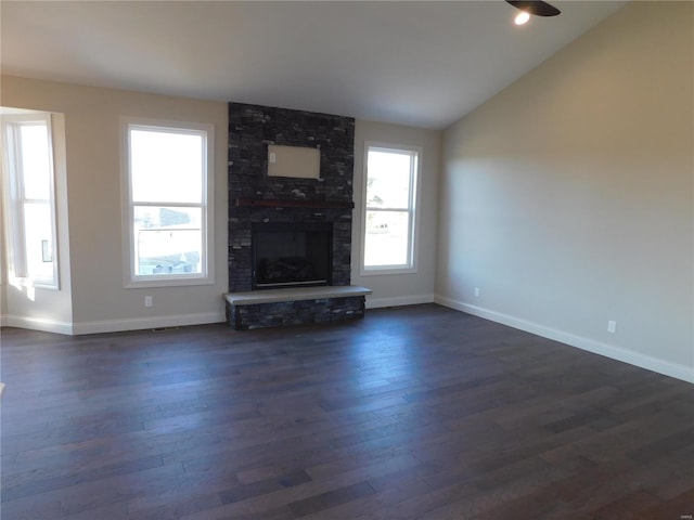 unfurnished living room featuring a large fireplace, dark wood-type flooring, vaulted ceiling, and baseboards