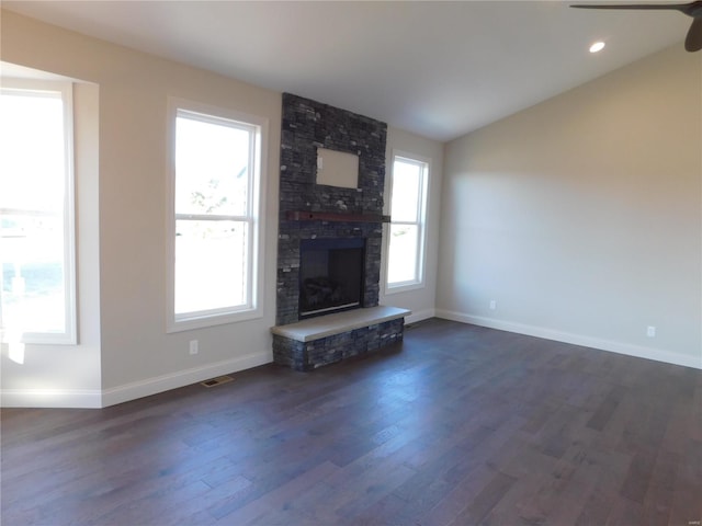 unfurnished living room featuring a large fireplace, baseboards, visible vents, dark wood-style flooring, and vaulted ceiling