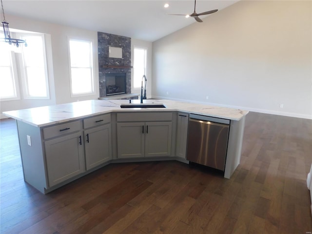 kitchen featuring a fireplace, dark wood-type flooring, open floor plan, a sink, and dishwasher