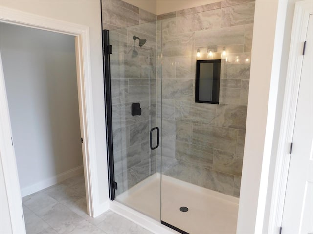 bathroom with a shower stall and baseboards