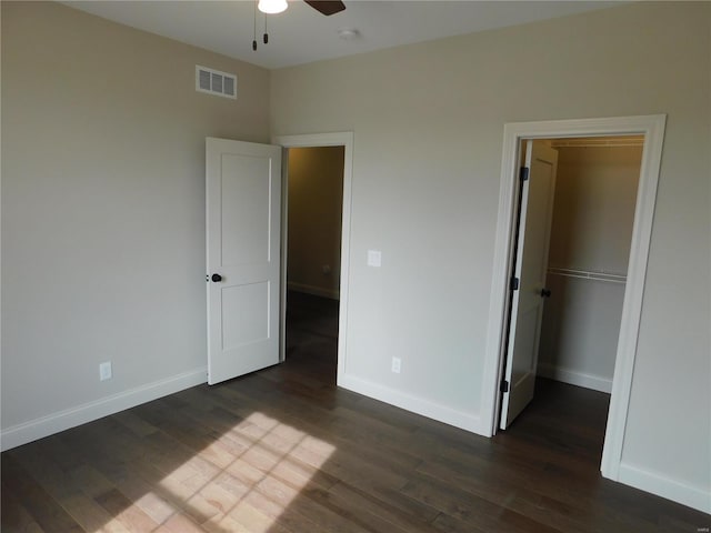 unfurnished bedroom featuring dark wood-type flooring, visible vents, and baseboards