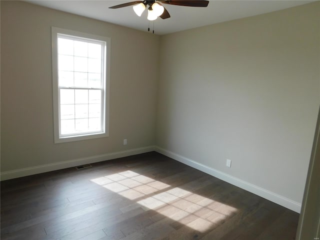 unfurnished room with visible vents, baseboards, ceiling fan, and dark wood-style flooring