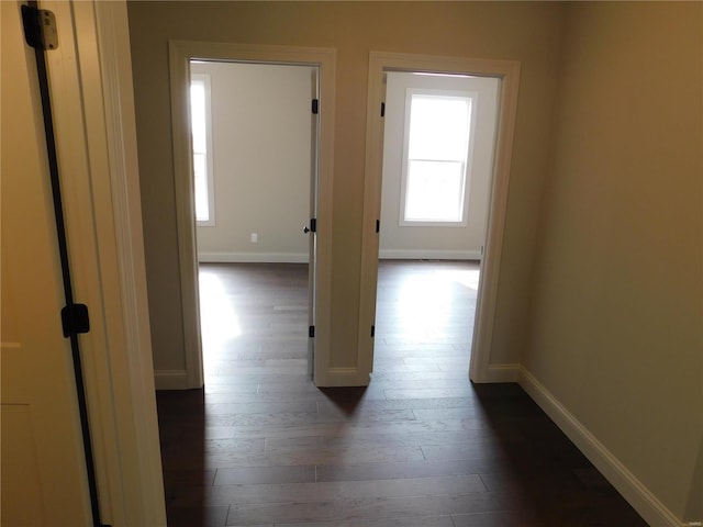 hall featuring dark wood-style floors and baseboards