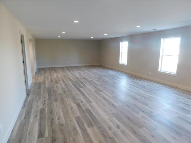 unfurnished room featuring recessed lighting, light wood-style flooring, and baseboards