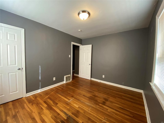 interior space with wood finished floors, visible vents, and baseboards