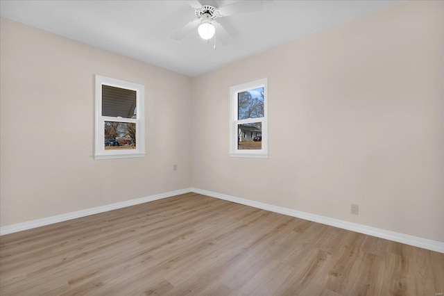 empty room featuring a ceiling fan, light wood-style flooring, and baseboards