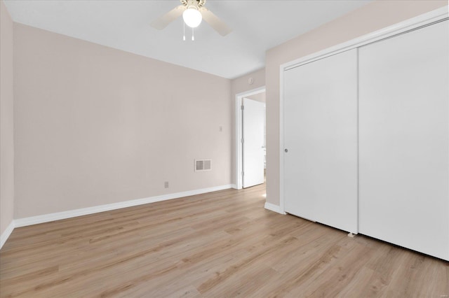 unfurnished bedroom featuring light wood finished floors, a closet, visible vents, and baseboards