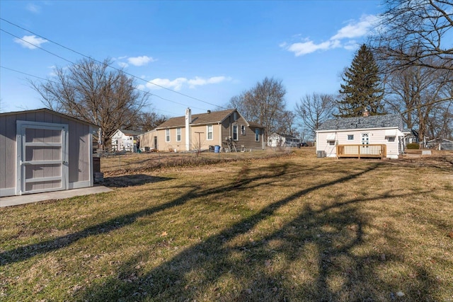 view of yard with a deck, a shed, and an outdoor structure