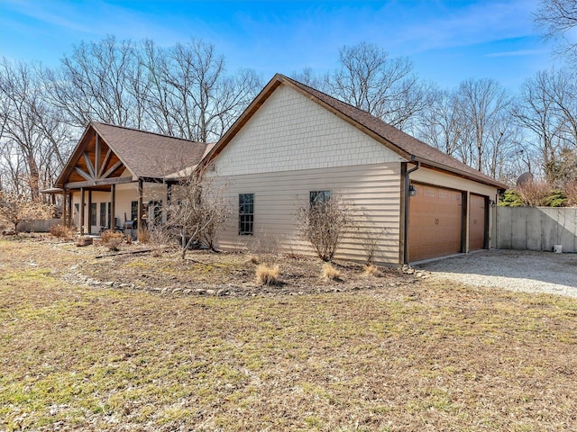 view of side of property featuring a garage and fence