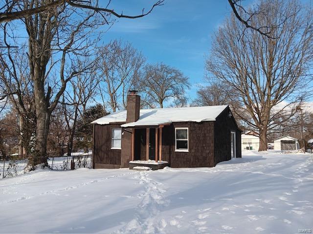 view of front of property with an outdoor structure and a chimney