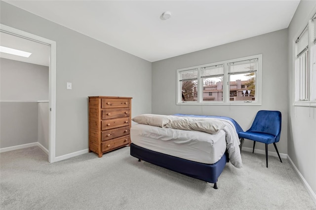 bedroom with a skylight, baseboards, and carpet