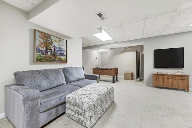 living area featuring a paneled ceiling, carpet, visible vents, and baseboards