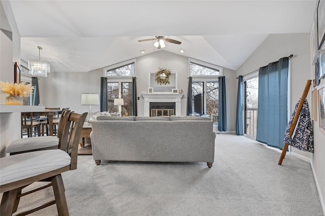 living area featuring light colored carpet, baseboards, vaulted ceiling, a glass covered fireplace, and an inviting chandelier