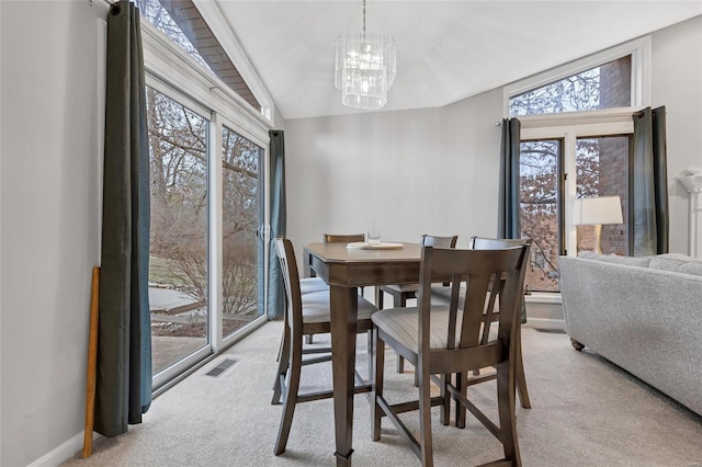 dining area with light carpet, an inviting chandelier, baseboards, and visible vents