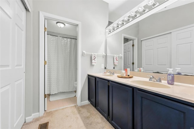 bathroom featuring visible vents, a sink, toilet, and double vanity