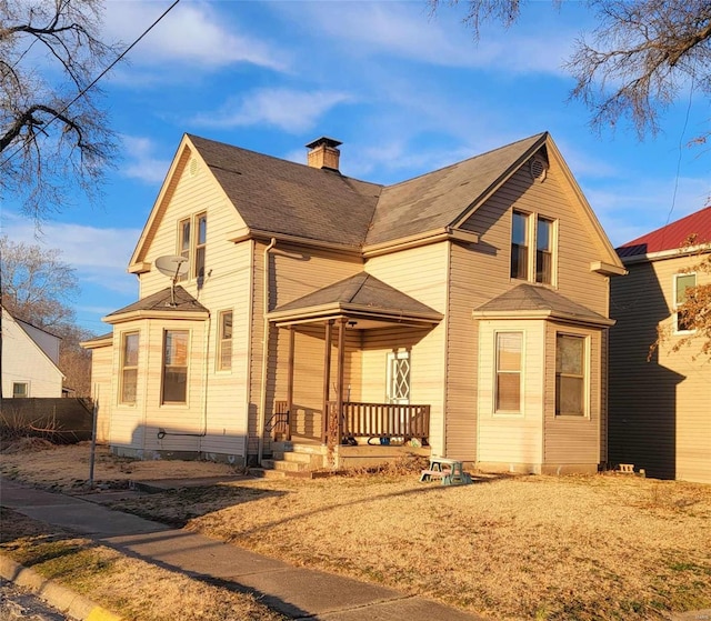 view of front facade featuring a porch and a chimney