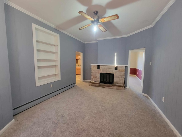 unfurnished living room featuring built in shelves, carpet, crown molding, baseboard heating, and a stone fireplace