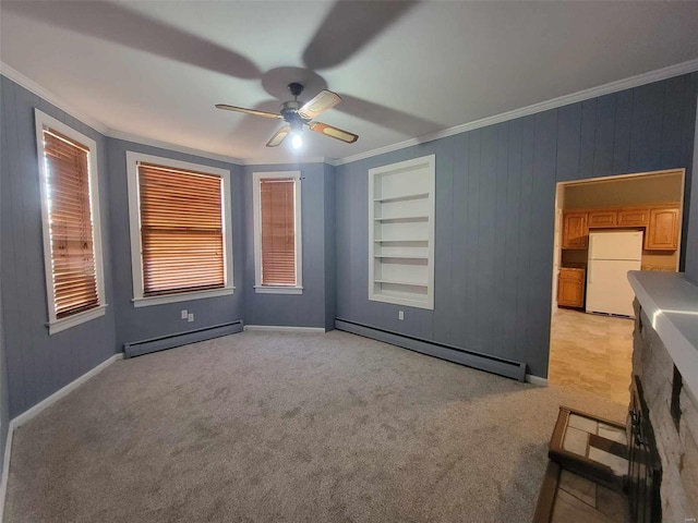 interior space featuring a baseboard heating unit, built in shelves, light colored carpet, and crown molding