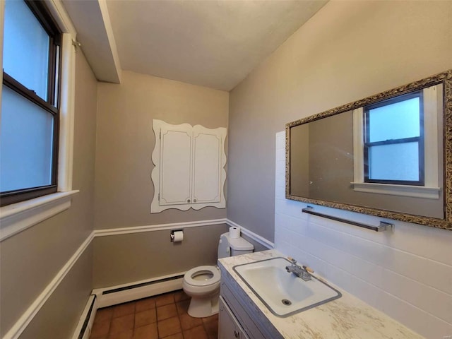 bathroom with a baseboard radiator, vanity, toilet, and tile patterned floors