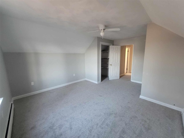 additional living space with a baseboard radiator, lofted ceiling, carpet flooring, ceiling fan, and baseboards