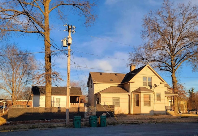 view of front of property featuring a chimney and fence