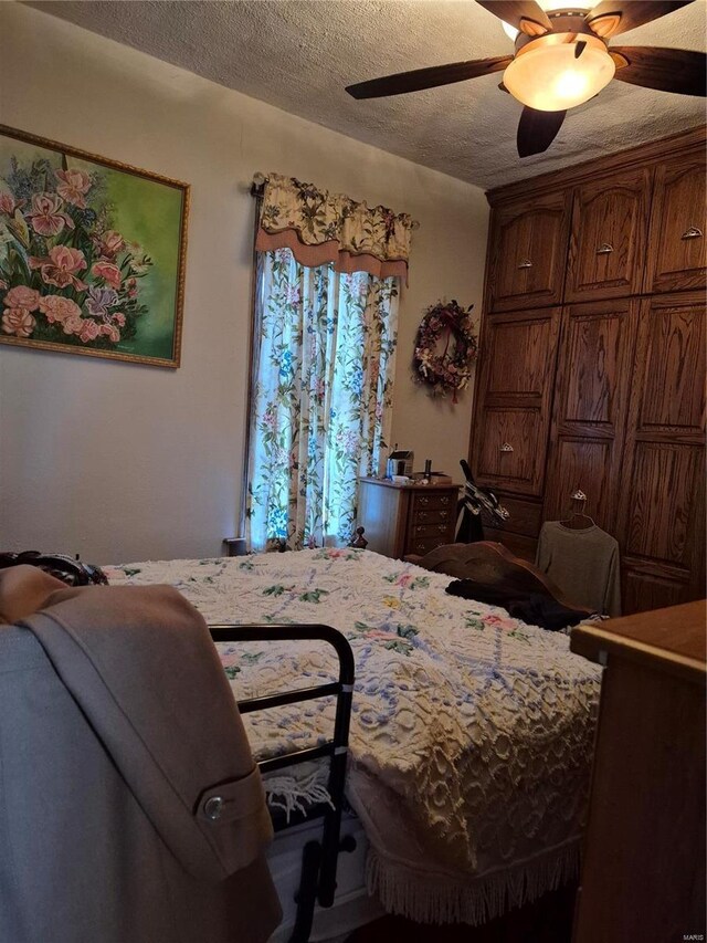 bedroom with ceiling fan and a textured ceiling