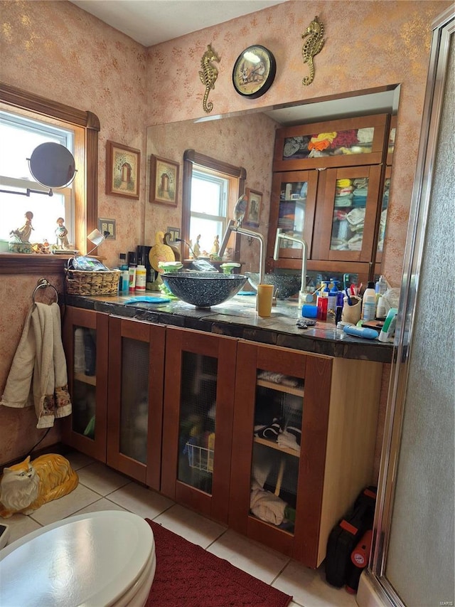 bar featuring a sink, light tile patterned floors, and wallpapered walls