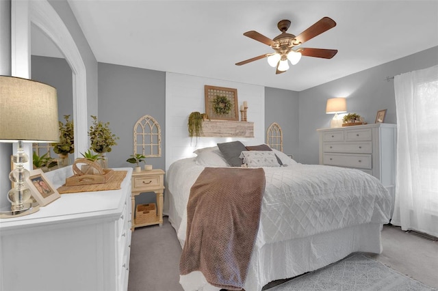 bedroom with a ceiling fan and light colored carpet