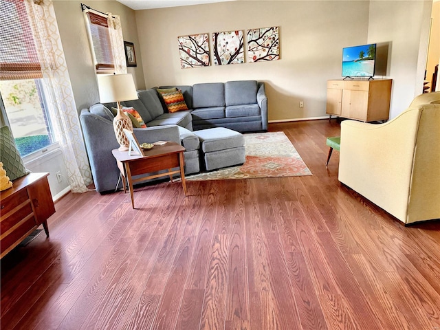 living room featuring dark wood-style floors and baseboards