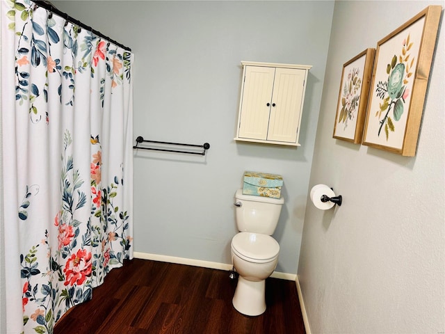 full bath with a shower with shower curtain, wood finished floors, toilet, and baseboards