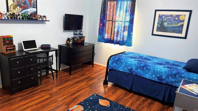 bedroom with wood finished floors and baseboards