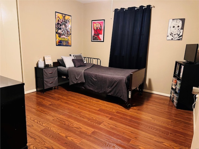 bedroom with baseboards and wood finished floors