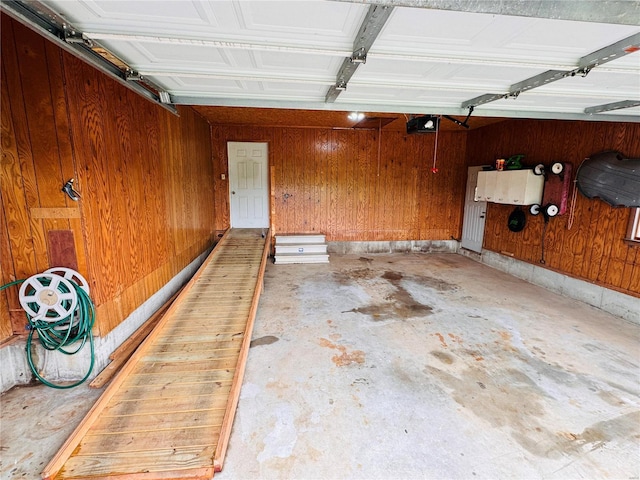 garage with wooden walls and a garage door opener