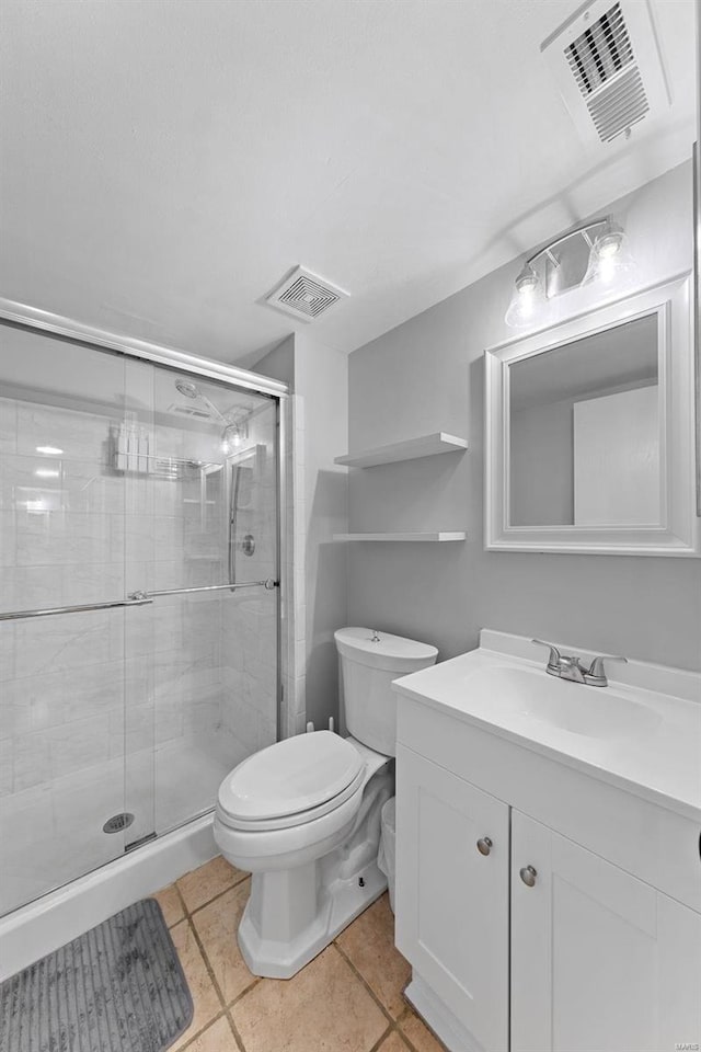 full bathroom featuring vanity, a shower stall, toilet, and visible vents