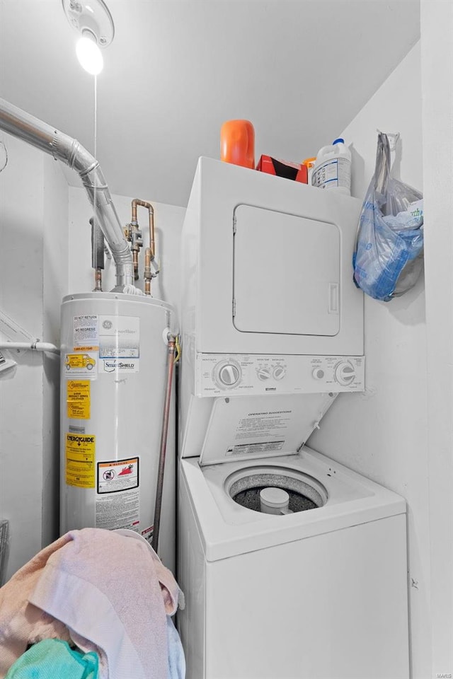 washroom featuring gas water heater, stacked washer / dryer, and laundry area