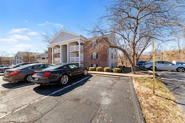 exterior space featuring brick siding and uncovered parking