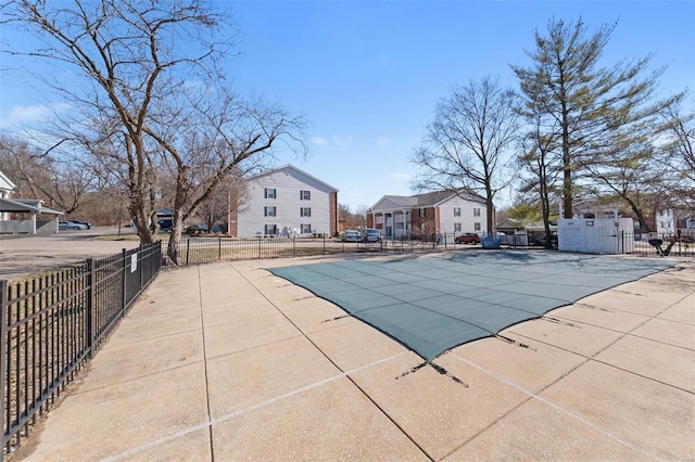 community pool with a residential view, a patio, and fence