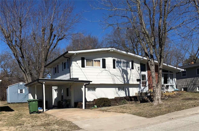 view of front facade featuring a carport, a storage shed, concrete driveway, and an outdoor structure