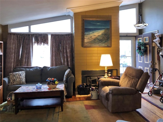 living room with plenty of natural light, vaulted ceiling, and wood finished floors