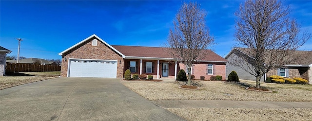 ranch-style house with driveway, brick siding, an attached garage, and fence