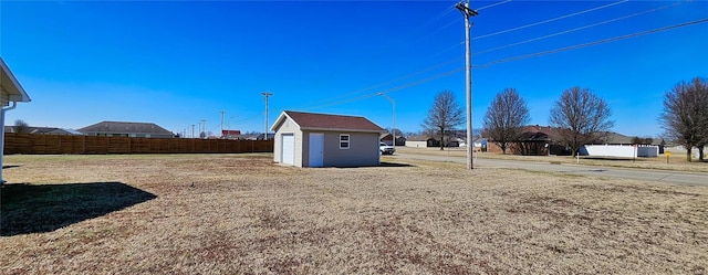 view of yard with an outbuilding, a shed, and fence