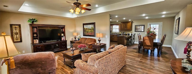 living room with dark wood-type flooring, recessed lighting, and baseboards