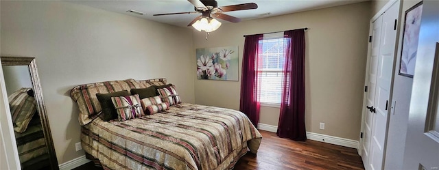 bedroom with multiple windows, visible vents, baseboards, and wood finished floors