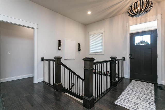 entryway featuring an inviting chandelier, wood finished floors, and baseboards