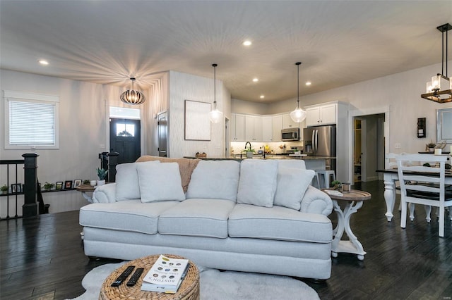 living area with recessed lighting, dark wood-style flooring, and a notable chandelier