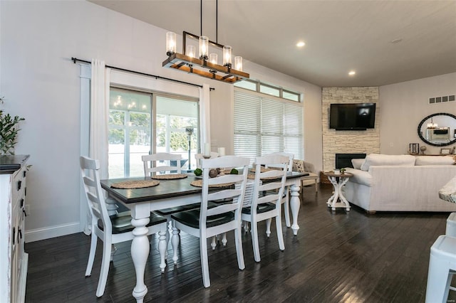 dining room with recessed lighting, visible vents, dark wood finished floors, and a stone fireplace