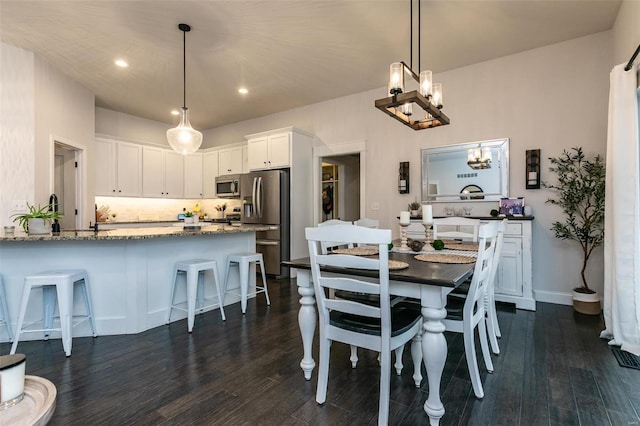 dining room with an inviting chandelier, baseboards, dark wood finished floors, and recessed lighting