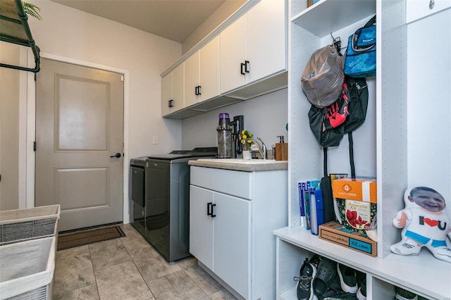 clothes washing area featuring a sink, cabinet space, and washer and dryer