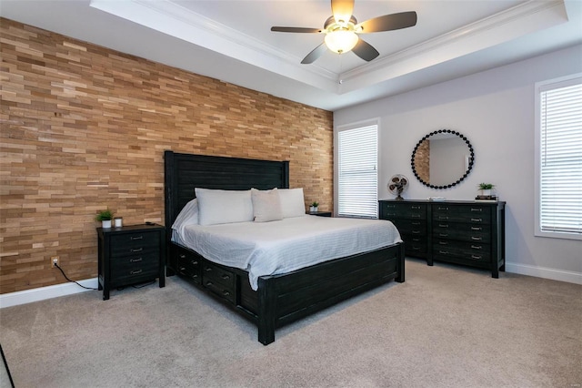 bedroom with ornamental molding, a tray ceiling, and carpet floors